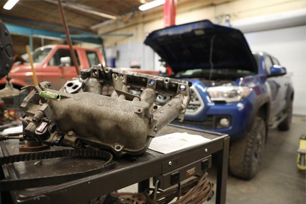 A car intake manifold in a garage.